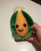 A plush ear of corn, its husk unzipped