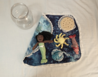 A plastic jar, its lid, and crocheted sea life
